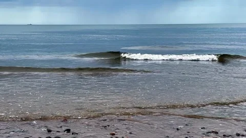 A beautiful beach with lightly rolling mild waves and shells on the sand wi.. 库存影片 295570274