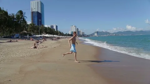 A beautiful beach. man jumping in the waves Vietnam Stock Footage 70763441