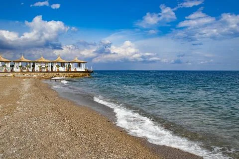Beautiful beach with pebbles and white beach houses in Kemer Turkey Stock Photos