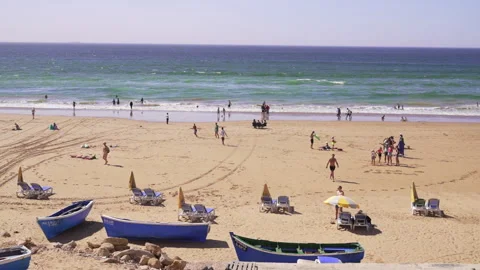 Beautiful Beach  with people having fun and fishing boats on the shore Stock Footage 240428904