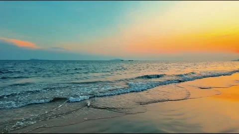 Beautiful Beach Sunset with Gentle Waves Crashing on Sandy Shore Stock Footage 332039643