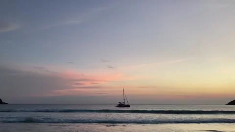 Beautiful beach when sunset with yacht in the middle of frame Stock Footage 137998939