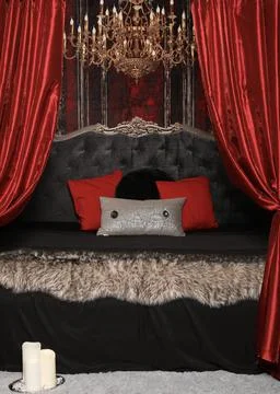 Beautiful bed with red curtains and a gold chandelier Stock Photos