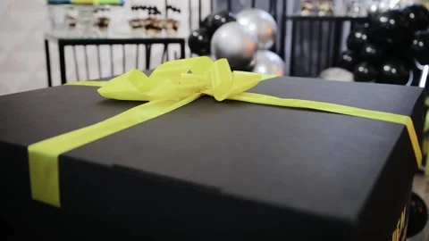 Beautiful big black box with large yellow bow. Celebration of child birthday Stock Footage 204124580