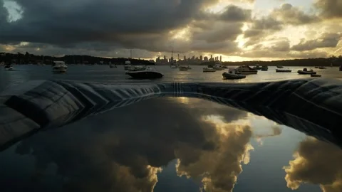 Beautiful big clouds at sunset reflected in a flooded boat &amp; Sydney 6K Stock Footage 302956236