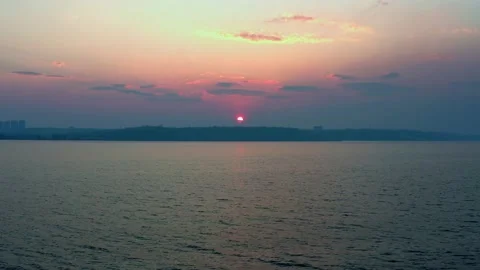 A beautiful big sun sets outside the city on a hill near the lake. Stock Footage 237029632
