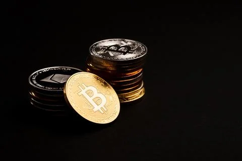 Beautiful bitcoin and stack of cryptocurrency coins on black background. Elite Stock Photos