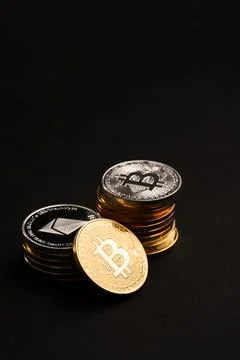 Beautiful bitcoin and stack of cryptocurrency coins on black background. Elite Stock Photos