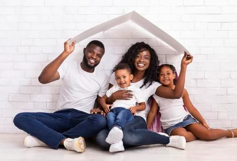 Beautiful Black Family Holding Cardboard Roof Dreaming Of New Home Stock Photos