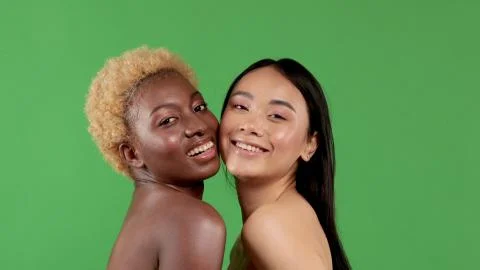 Beautiful black woman with afro hair and pretty asian woman having fun smiling Stock Photos