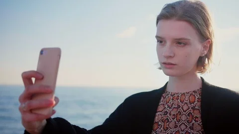 Beautiful blond lady making selfie with phone on the beach, stylish haircut Stock Footage 105599225