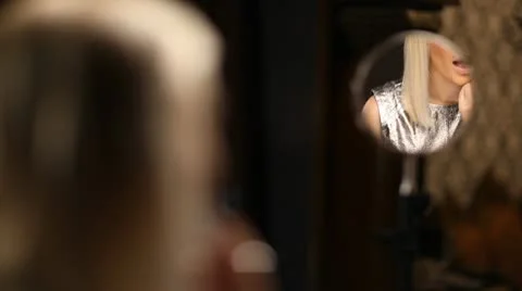 Beautiful blond model applying lipstick in the mirror Stock-Footage 10583816