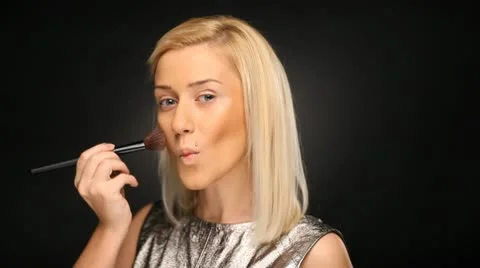 Beautiful blond model applying make-up with a brush, beauty shot Stock Footage 10583750