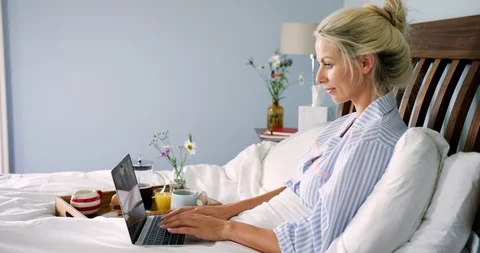 Beautiful Blond Woman Having Breakfast In Bed And Using Laptop Stock Footage