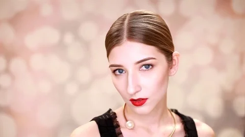 Beautiful blond young woman in elegant black dress holding finger on lips Stock Footage