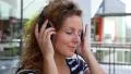Beautiful Blonde Curly Woman Listening to Music in the City. HD Footage