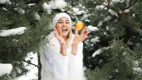 Beautiful blonde eats tangerine against background of winter landscape Stock-Footage 70481879