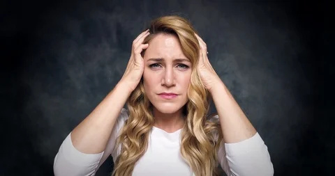 Beautiful blonde is experiencing headache and stress on a dark background. Stock Footage 115108080