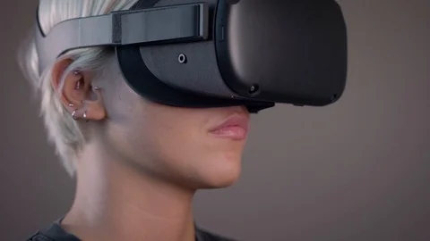 Beautiful blonde girl looking around in VR glass, oculus rift, close up Stock Footage