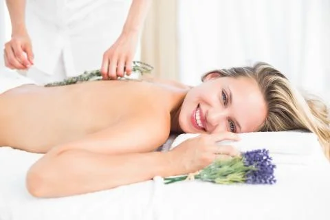 Beautiful blonde lying on massage table with lavanda Stock Photos