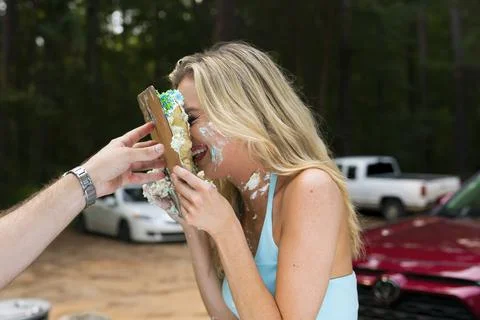 A Beautiful Blonde Model Eats Her Birthday Cake At A Local Picnic Stock Photos