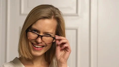 Beautiful blonde model with glasses winks on camera Stock Footage 103628037