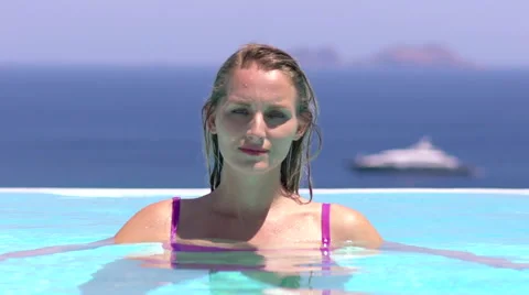 Beautiful blonde model leans back in pool slow motion Stock Footage 67870533
