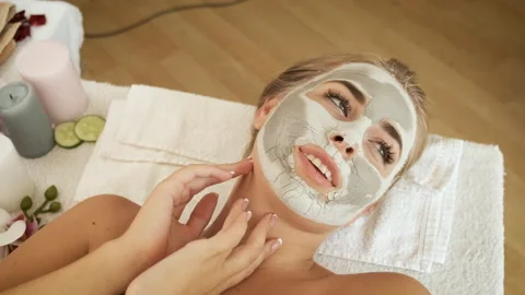 Beautiful blonde model with a mask on her face lies on the table in the spa and Stock Footage 139271053