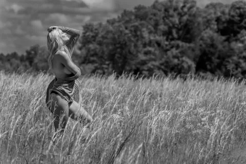 A Beautiful Blonde Model Poses Implied Nude In A Field Outdoors Stock Photos