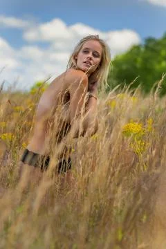 A Beautiful Blonde Model Poses Implied Nude In A Field Outdoors Stock Photos