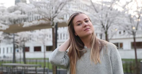 Beautiful blonde poses for the camera and smiles corrects her hair Stock Footage 129079748