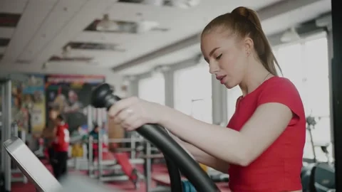 A beautiful blonde quickly runs down the treadmill in the hall. Stock Footage 154894264