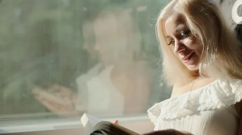 Beautiful blonde  reading a book in the train Stock Footage 59798758