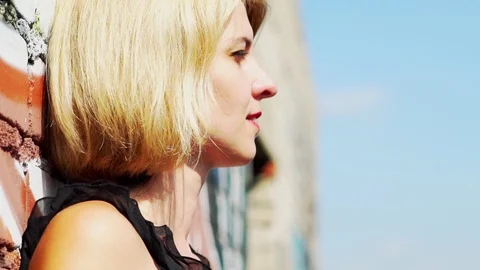 Beautiful blonde standing at the brick wall Stock Footage 113607245