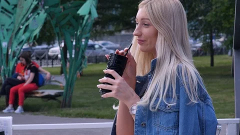 Beautiful blonde is talking on the phone during a lunch in a cafe. She smiles Stock Footage 121817458