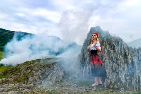 Beautiful blonde woman in old-fashioned dress surrounded by smoke Stock Photos
