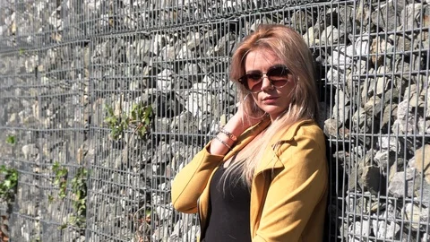 Beautiful blonde in a yellow jacket Stock Footage 116607963