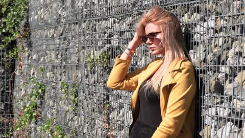 Beautiful blonde in a yellow jacket Stock Footage 117570558