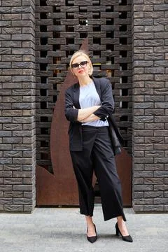 Beautiful blonde young woman wearing suit and walking on the street. A woman  Stock Photos