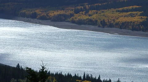 BEAUTIFUL BLUE GLACIAL LAKE WITH YELLOW ORAGNE ASPENS Stock Footage 59069019