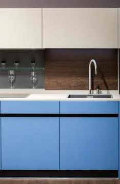 Beautiful blue kitchen unit, kitchen faucet, wooden apron in the kitchen. Mod Stock Photos