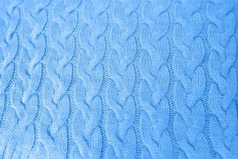 Beautiful blue knitted braid pattern of light brown wool yarn, knitted text.. Stock Photos