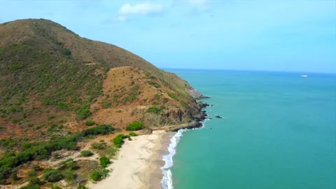 A beautiful blue ocean with a rocky cliff in the background Видео 294932053