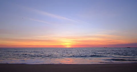 Beautiful blue / orange gradient sky at sunset on the beach with wispy clouds Video stock 139534124