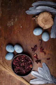 Beautiful blue painted easter eggs with dry Hibiscus tea, silver feathers Stock Photos