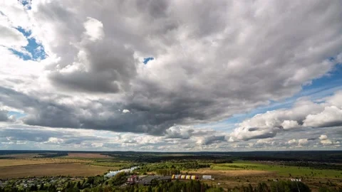 Beautiful blue sky with puffy white clouds over luscious green landscape, time Stock Footage 223380249