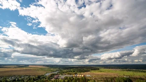 Beautiful blue sky with puffy white clouds over luscious green landscape, time Stock Footage 223945800