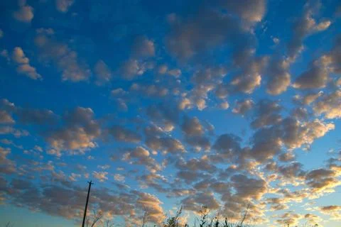 Beautiful blue sky with small clouds at sunset Stock Photos