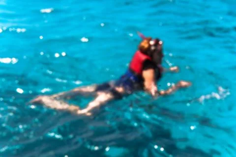 Beautiful blurred blue sea bathing game. Ocean theme with people for backgrou Stock Photos