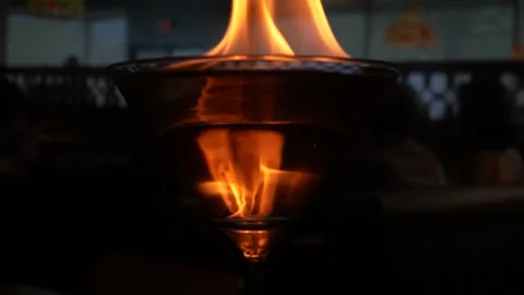 Beautiful bobbing flames on top of a martini glass filled with water Stock Footage 242330516